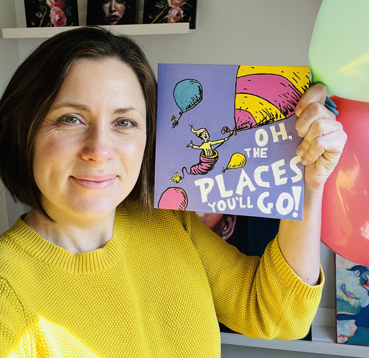 Louise holding painting of book cover Oh the Places You'll Go
